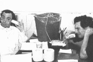 A couple guys hamming it up with a garbage-pail 'C-Meter', toilet
paper, etc. Toilet rolls are being used as a telephone into the garbage
pail; nice symbology.